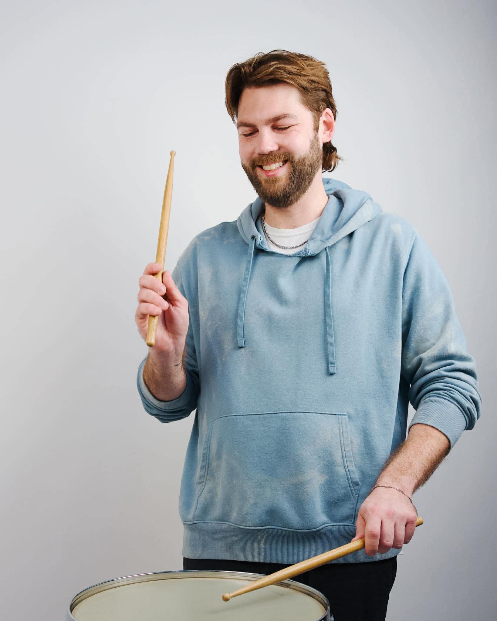 Ben playing drums in blue hoodie
